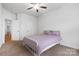 Cozy bedroom with soft carpet and ceiling fan showcasing a bed with purple bedding and two doors at 7186 Barleywood Dr, Locust, NC 28097