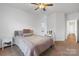 Tranquil bedroom with carpet, ceiling fan, and a vanity near the bed with neutral bedding and two side tables at 7186 Barleywood Dr, Locust, NC 28097