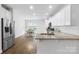 The kitchen has white cabinets, stainless steel appliances, granite countertops, and hardwood floors at 7186 Barleywood Dr, Locust, NC 28097