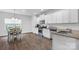 Well-lit kitchen featuring white cabinets, stainless steel appliances, granite countertops, and hardwood floors at 7186 Barleywood Dr, Locust, NC 28097