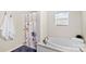 Relaxing bathroom with a soaking tub and floral shower curtain under a window at 775 Bolick Rd, Fort Mill, SC 29707