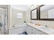 Bright bathroom with dual sinks, white cabinets, and a soaking tub under a window at 775 Bolick Rd, Fort Mill, SC 29707
