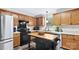 Bright kitchen showcasing wood cabinets, black appliances, and a central island with breakfast bar at 775 Bolick Rd, Fort Mill, SC 29707
