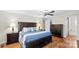 Well-lit main bedroom with wood flooring features a large bed, dresser, and walk-in closet at 775 Bolick Rd, Fort Mill, SC 29707