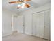 Bright bedroom featuring a ceiling fan, neutral carpeting, and closet doors for ample storage at 819 Old Dutch W Rd, Indian Trail, NC 28079