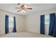 Bedroom with neutral walls and carpet, a ceiling fan, and a pair of windows with blue curtains at 819 Old Dutch W Rd, Indian Trail, NC 28079