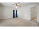 Bedroom with neutral walls and carpet, a ceiling fan, and a window with blue curtains at 819 Old Dutch W Rd, Indian Trail, NC 28079