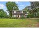 Inviting brick home with a well-maintained lawn and mature trees, offering a serene and picturesque setting at 819 Old Dutch W Rd, Indian Trail, NC 28079