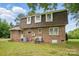 Back of house with brick exterior and well-maintained yard with mature trees at 819 Old Dutch W Rd, Indian Trail, NC 28079