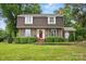 Attractive brick home featuring manicured bushes, a red front door, and a lush green lawn at 819 Old Dutch W Rd, Indian Trail, NC 28079