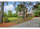 Quaint brick home with mature trees, and a gravel driveway, providing a private and secluded feel at 819 Old Dutch W Rd, Indian Trail, NC 28079