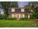 Charming brick home with lush landscaping, red door, and a well-manicured lawn, creating inviting curb appeal at 819 Old Dutch W Rd, Indian Trail, NC 28079