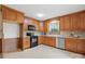 Well-lit kitchen with wood cabinetry, black appliances, and modern countertops at 819 Old Dutch W Rd, Indian Trail, NC 28079
