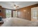 Spacious living room with wood paneling, large windows, and neutral carpeting at 819 Old Dutch W Rd, Indian Trail, NC 28079