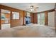 Charming living room featuring wood paneling, fireplace, and view into the kitchen at 819 Old Dutch W Rd, Indian Trail, NC 28079