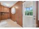 Cozy mud room with wood paneling, storage cabinets, and a bright white door leading to the outdoors at 819 Old Dutch W Rd, Indian Trail, NC 28079