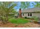 Large, green backyard featuring a brick patio with a metal pergola and mature trees at 8605 Ducksbill Dr, Charlotte, NC 28277