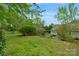 Spacious backyard with mature trees, a cozy patio area, and lush lawn, ideal for outdoor enjoyment and entertaining at 8605 Ducksbill Dr, Charlotte, NC 28277