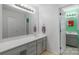 Bathroom boasts an extended countertop with gray cabinets and a large mirror at 8605 Ducksbill Dr, Charlotte, NC 28277