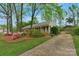 A view of the home and driveway framed by trees and colorful azaleas at 8605 Ducksbill Dr, Charlotte, NC 28277