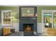Fireplace with brick surround, hardwood floors, and backyard view at 8605 Ducksbill Dr, Charlotte, NC 28277