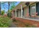 Inviting covered front porch with seating, brick base, and flower baskets at 8605 Ducksbill Dr, Charlotte, NC 28277