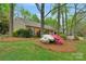 Charming home with manicured front yard featuring mature trees, colorful azaleas, and lush landscaping at 8605 Ducksbill Dr, Charlotte, NC 28277