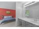 Main bedroom featuring red accent wall, bed and ensuite bath with vanity at 8605 Ducksbill Dr, Charlotte, NC 28277