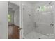 Bathroom featuring a tile shower with glass door, shower niche, and wood flooring at 869 Kathryn Se Dr, Concord, NC 28025