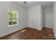 A simple bedroom boasts wood-look floors, a window, and a closet with paneled doors at 869 Kathryn Se Dr, Concord, NC 28025