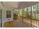 Covered porch overlooking the wooded backyard with wood floors and railing at 869 Kathryn Se Dr, Concord, NC 28025
