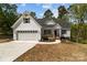 Charming home featuring a white exterior, covered porch, attached garage, and well-manicured lawn at 869 Kathryn Se Dr, Concord, NC 28025