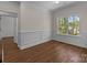 Bright room features wood flooring, large window with view, and classic wainscoting detail at 869 Kathryn Se Dr, Concord, NC 28025