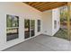 A covered patio with white siding, windows, sliding glass door, and a concrete floor offers outdoor relaxation at 869 Kathryn Se Dr, Concord, NC 28025