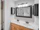 Bathroom featuring double sinks with wood cabinets, framed mirrors, and modern light fixtures at 1000 Potters Bluff Rd, Monroe, NC 28110