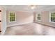 Spacious bedroom with wood-look flooring, three windows, and a ceiling fan at 1000 Potters Bluff Rd, Monroe, NC 28110