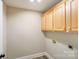 Laundry room features wood-look flooring and light wood cabinets at 1000 Potters Bluff Rd, Monroe, NC 28110