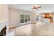 Open concept living room with fireplace, fan and view into kitchen and backyard at 1000 Potters Bluff Rd, Monroe, NC 28110