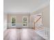 Bright living room featuring hardwood floors, staircase, and double windows at 1000 Potters Bluff Rd, Monroe, NC 28110