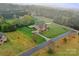 Stunning aerial view of an estate home featuring a lush lawn, inviting pool, and a private, wooded backdrop at 1012 Harper Lee Dr, Newton, NC 28658