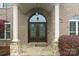 Elegant entryway with arched double doors, stone accents and grand columns at 1012 Harper Lee Dr, Newton, NC 28658