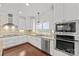 Bright kitchen features custom cabinets, stainless appliances, mosaic backsplash, and granite countertops at 1012 Harper Lee Dr, Newton, NC 28658