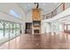 Open living room showcasing a grand stone fireplace, staircase, and views of the pool and outdoor patio at 1012 Harper Lee Dr, Newton, NC 28658