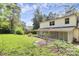 A lush backyard featuring healthy, green grass, mature trees, and a screened-in back porch at 10432 Camelback Cir, Charlotte, NC 28226