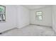 This upstairs bedroom has a window, new carpet and a freshly painted white walls at 10432 Camelback Cir, Charlotte, NC 28226
