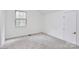 Upstairs bedroom with new carpet, freshly painted white walls, and a window at 10432 Camelback Cir, Charlotte, NC 28226