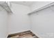 Walk-in closet with white walls and wood-look flooring at 10432 Camelback Cir, Charlotte, NC 28226