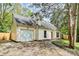 Charming cream colored home with a well-maintained lawn and attached garage, shaded by mature trees at 10432 Camelback Cir, Charlotte, NC 28226
