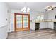 Bright kitchen with light countertops, stainless steel appliances, and elegant sliding glass doors to a sunroom at 10432 Camelback Cir, Charlotte, NC 28226