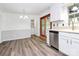 Bright kitchen with white cabinets, stainless steel appliances, and wood-look flooring at 10432 Camelback Cir, Charlotte, NC 28226